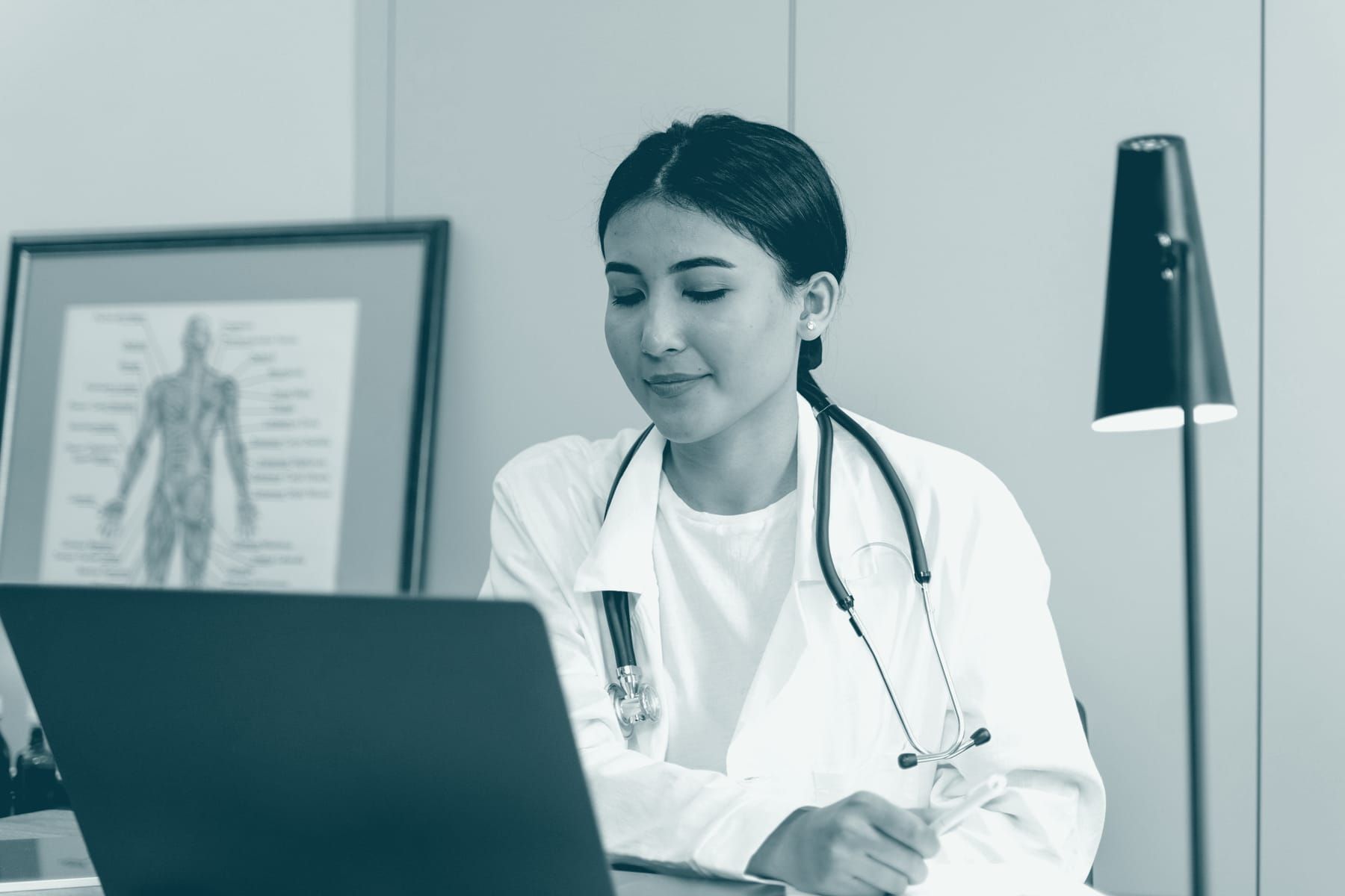 Une médecin prend des notes à son bureau de consultation.