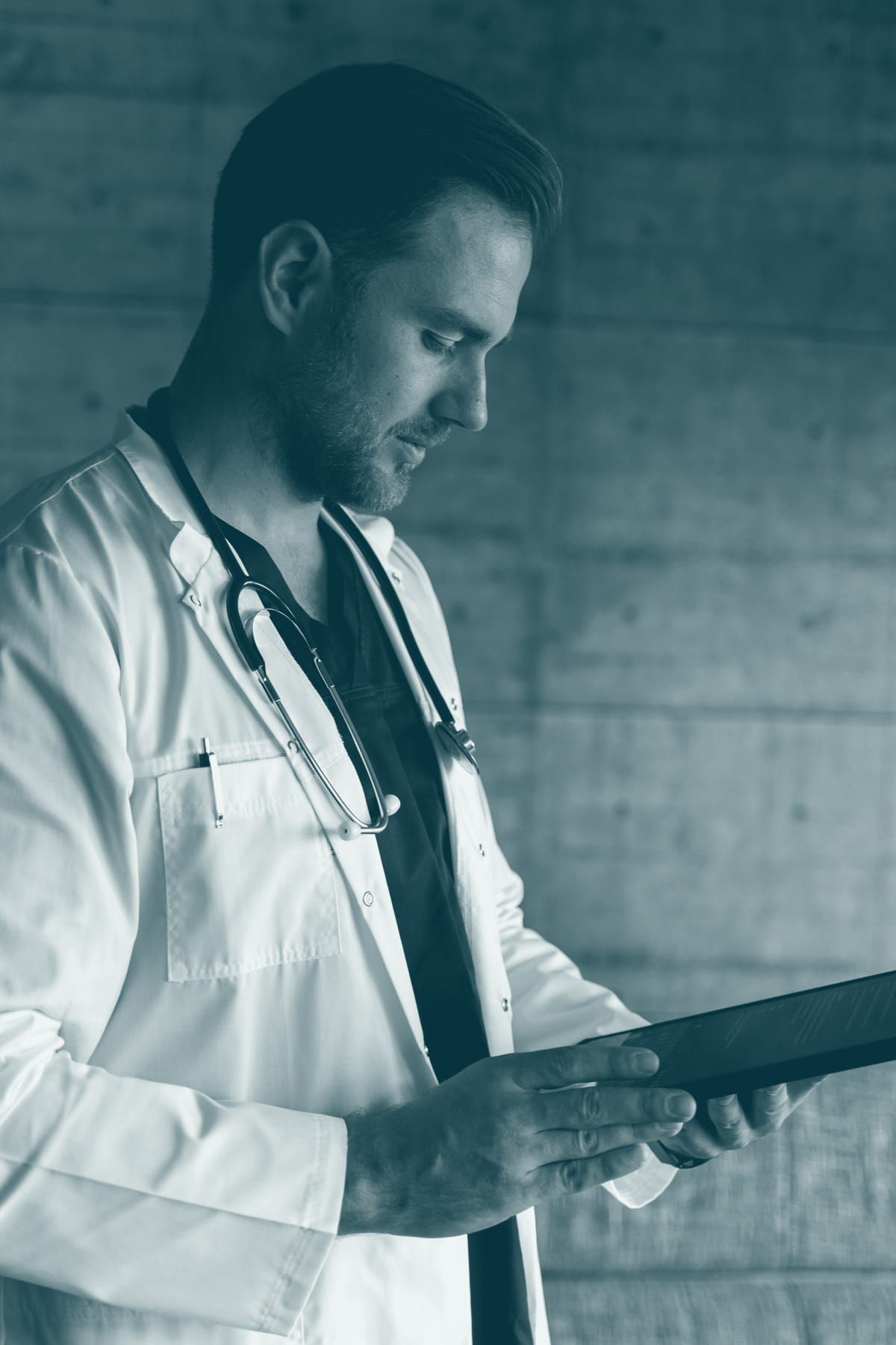 Un médecin consulte un dossier sur sa tablette.