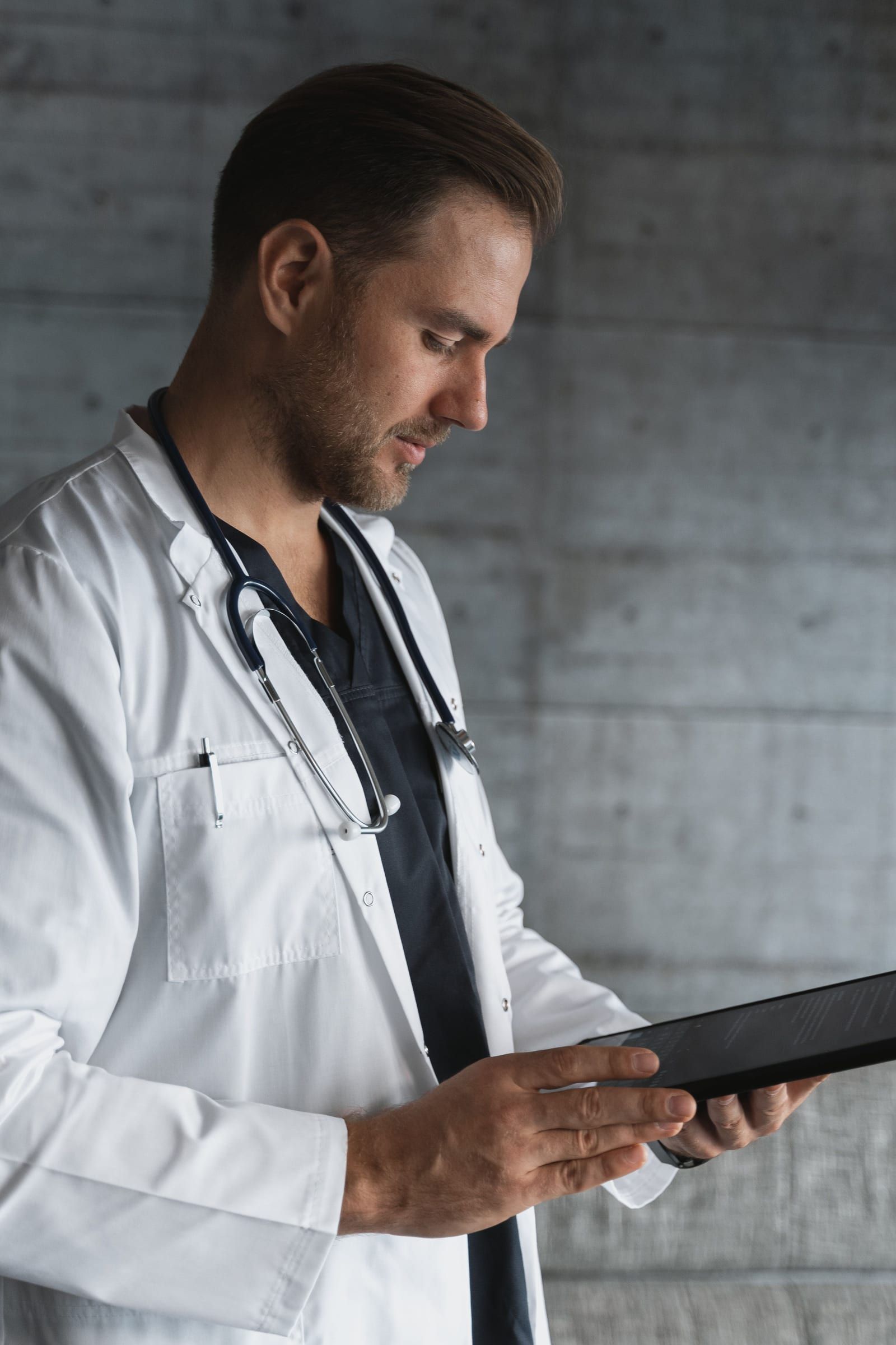 Un médecin consulte un dossier sur sa tablette.