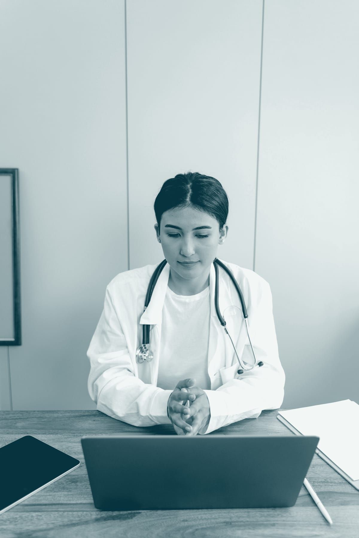 Une médecin devant son ordinateur, à son poste de consultation.
